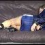 SANDRA tied and gagged with a bar on a brown bed wearing supersexy blue shiny nylon shorts, highheels and a blue rain jacket (Video)