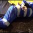 Lucy tied and gagged on bed with tape wearing sexy blue shiny nylon rainwear (Video)