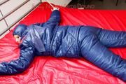 Pia hooded, tied and gagged on bed in a dark blue old school down ski suit