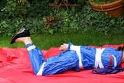 Nicole in an blue sauna suit tied and gagged in the garden (Pics)