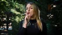 Blond lady is smoking white cigarette outdoors