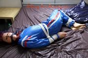 Mara tied and gagged on bed wearing s shiny blue PVC sauna suit (Pics)