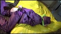 Lucy tied, gagged and hooded on bed on a bar wearing sexy purple rainwear (Video)