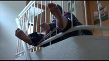 Jill tied, gagged and hooded with a bar on the stairway wearing a sexy oldschool downwear combination (Video)