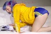 SEXY MARA lounging on the sofa wearing a sexy blue/yellow shiny nylon shorts and a yellow shiny nylon rain jacket (Pics)