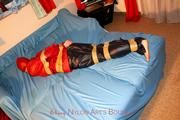 one of our archive girls tied and gagged in shiny nylon rainwear