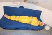 Archive girl tied and gagged by using tape on a sofa wearing an yellow rainsuit (Pics)