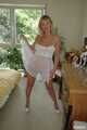 Busty blonde Marlen posing in a white negligee in the bedroom