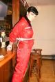 Jill tied and gagged on a pillar wearing a shiny red rainwear (Pics)