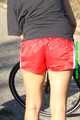 Watch Sandra riding her bike enjoying her red shiny nylon Shorts