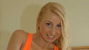 Busty blonde Anna in a orange top and hotpants on bed with oil