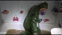 Mara wearing a sexy green shiny pvc jumpsuit with hood ties and gagges herself in a bath tub full of mud (Video)