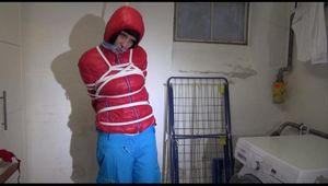 Mara tied, gagged and hooded in a laundry wearing a sexy blue down pants and a red down jacket (Video)