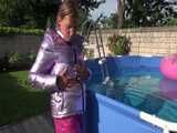 Watch Sandra enjoying her shiny nylon Downwear at a warm Summer Day in the Garden and in the Pool