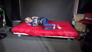 Watching Sonja wearing a supersexy black shiny nylon down jacket and a blue shiny nylon rain pants being tied, gagged and hooded with ropes  and a clothgag on a bed (Video)