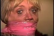 50 Yr OLD REAL ESTATE AGENT IS NUDE, TIT TIED, CROTCH ROPED, WRAP BONDAGE TAPE GAGGED, CLEAR TAPE GAGGED AND  HANDGAGGED WHILE TIED TO A CHAIR (D71-15)