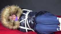 Watching Sonja wearing a supersexy black shiny nylon down jacket and a blue shiny nylon rain pants being tied, gagged and hooded with ropes  and a clothgag on a bed (Video)