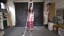 Ayana in a shiny nylon red rainsuit and a see through PVC Rainjacket, tied gagged, hooded and vibed